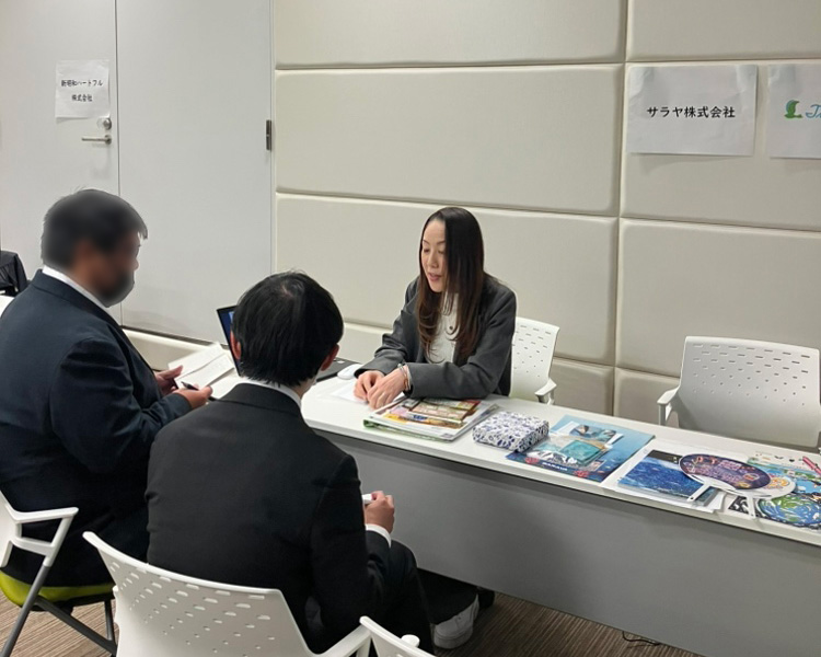 学生に企業説明中の画像